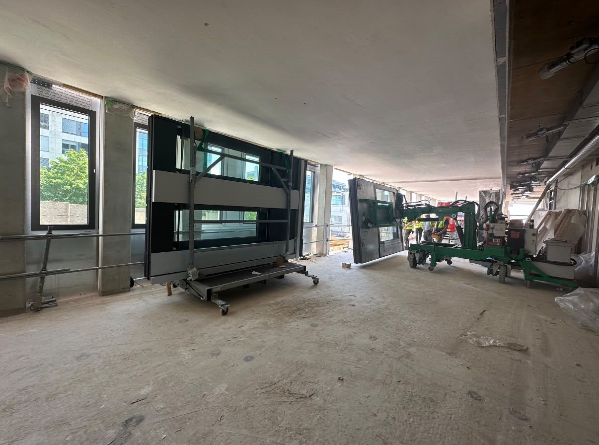 Glazed façade units staged inside a building under construction