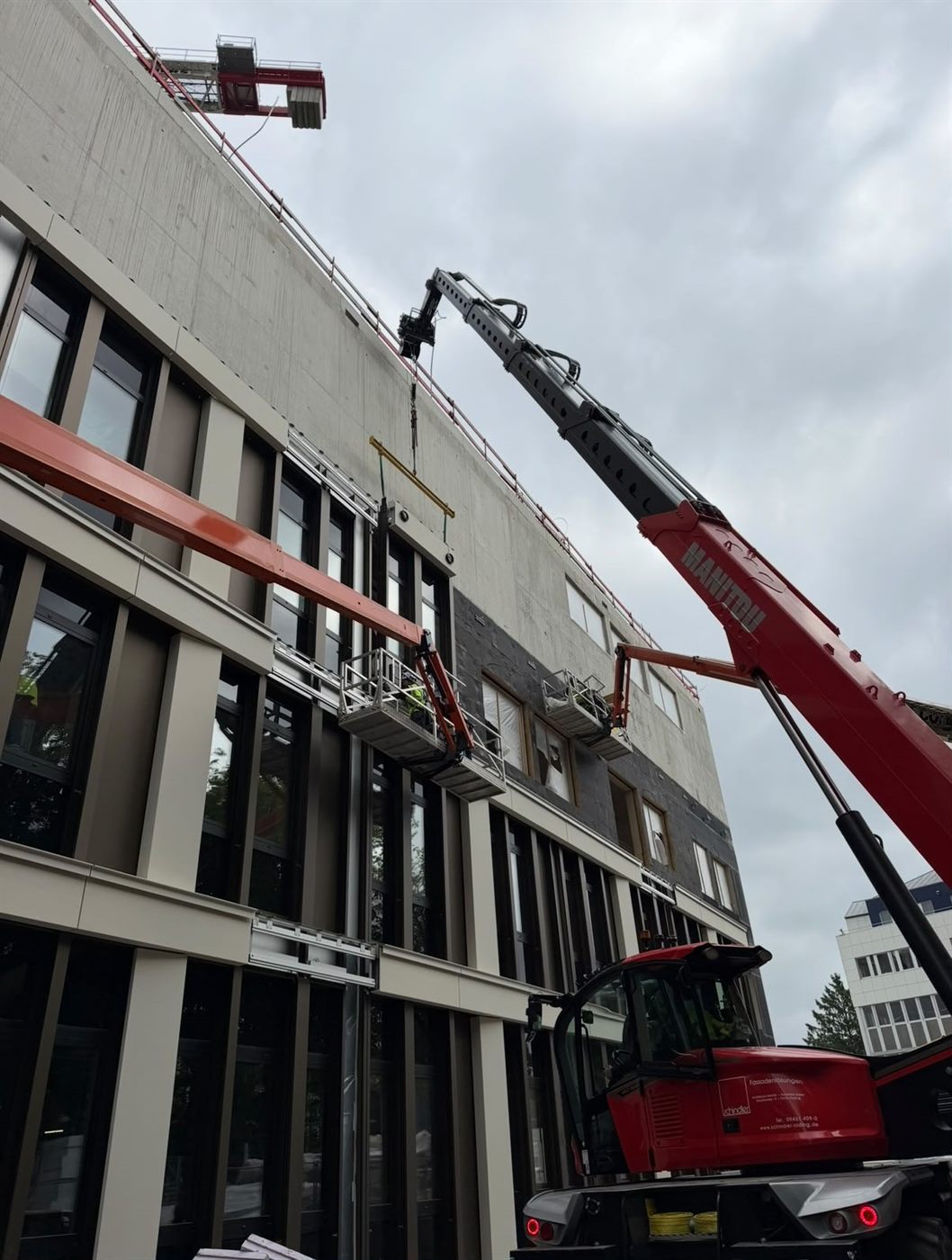 Telehandler and access platforms installing façade panels