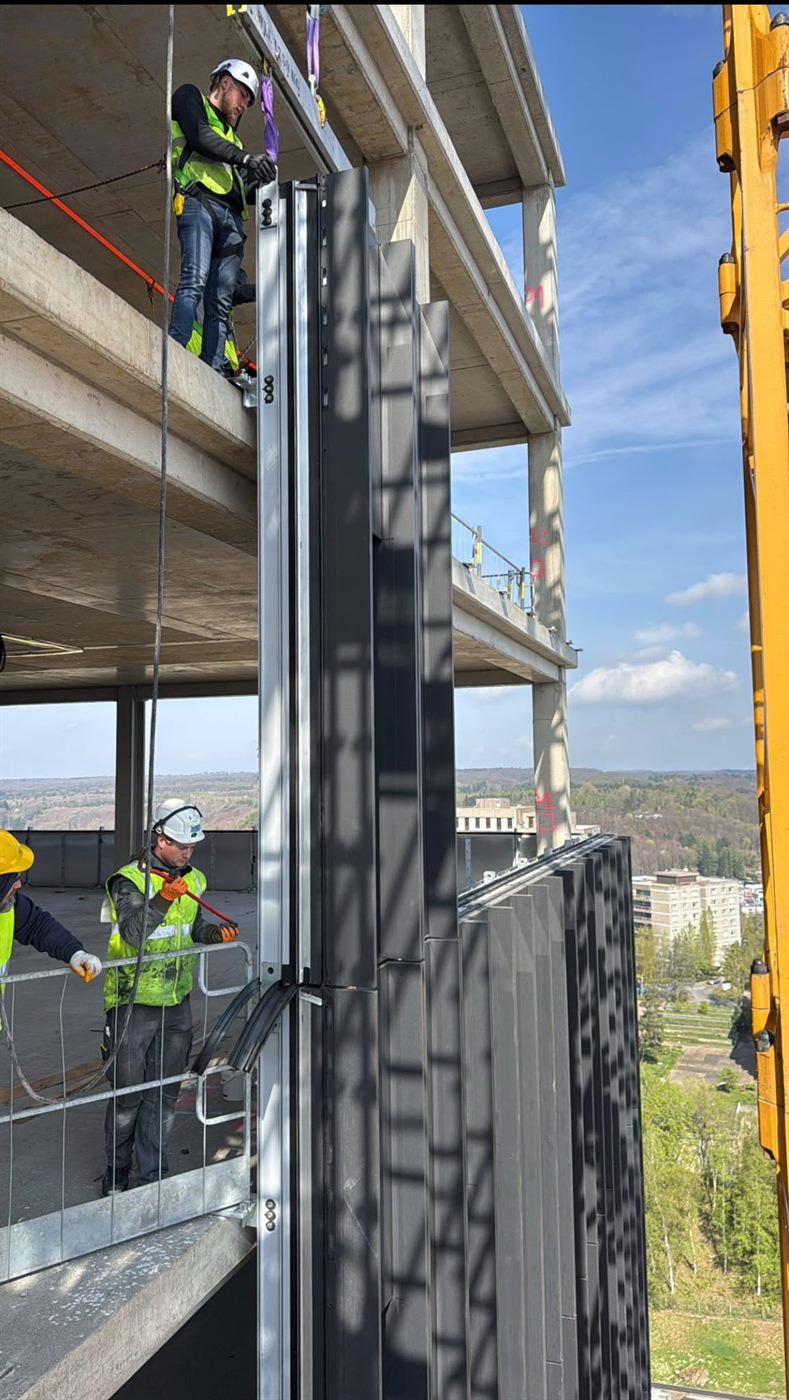 Operatives working at height installing tall façade fins